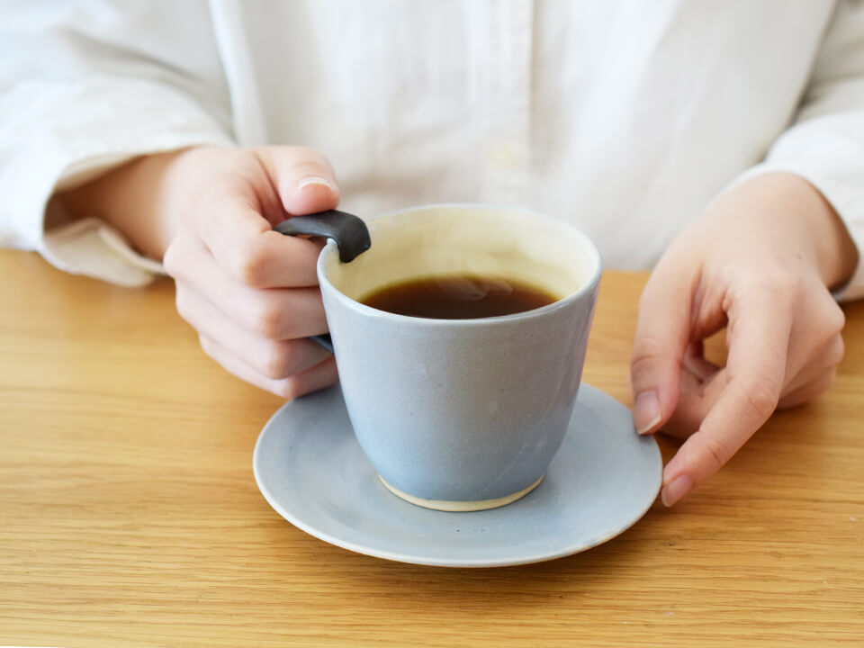 コーヒーカップに手を添えている