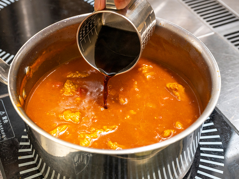 カレーに、コーヒーを注ぎ入れる