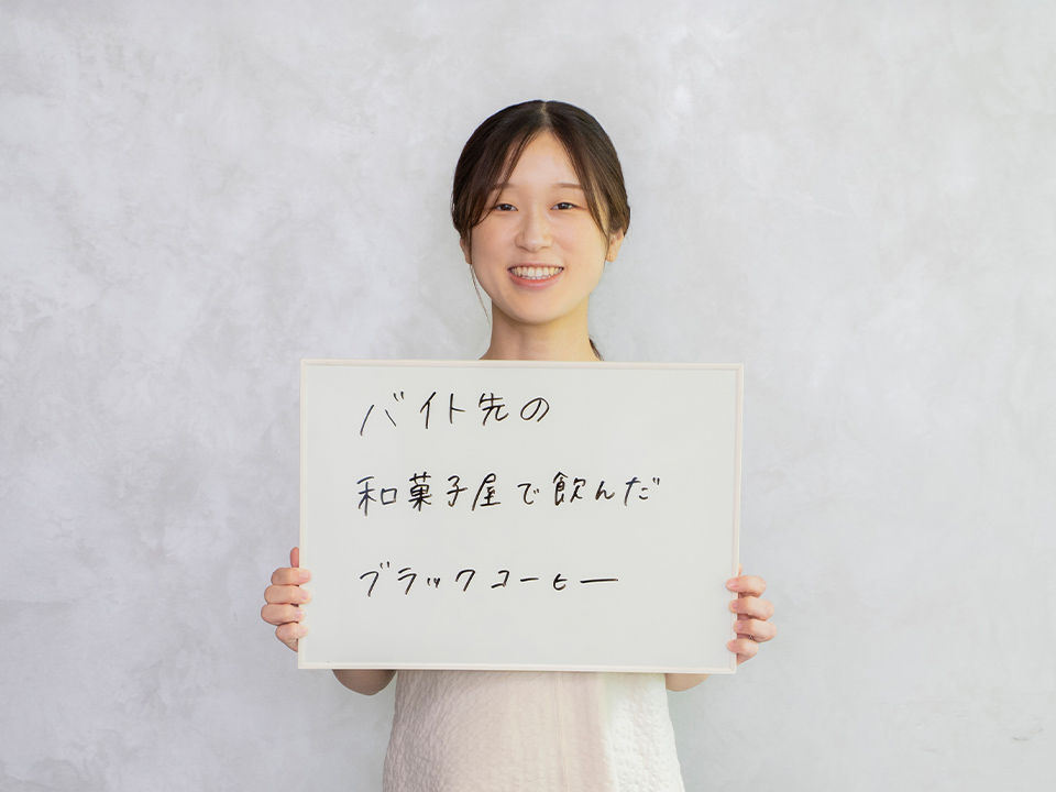 ボードに「バイト先の和菓子屋で飲んだブラックコーヒー」と書かれているのを持っている様子